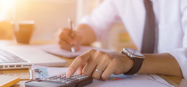 Businessman accountant using calculator and laptop for calculating finance on desk office. business financial accounting concept.